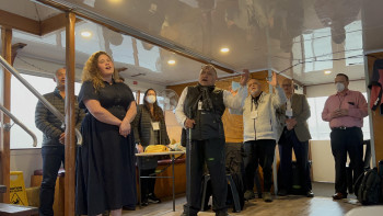 A group of Māori delegation members offer a waiata inside a riverboat main cabin